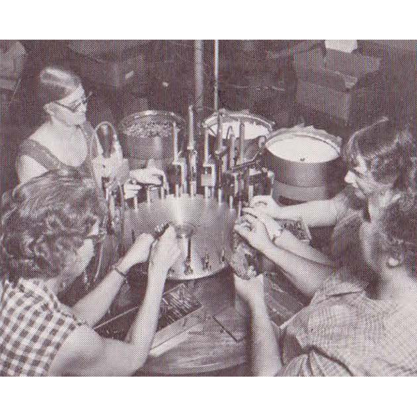 Four Employees producing pens with a retractable pen assembly machine in the 1960s